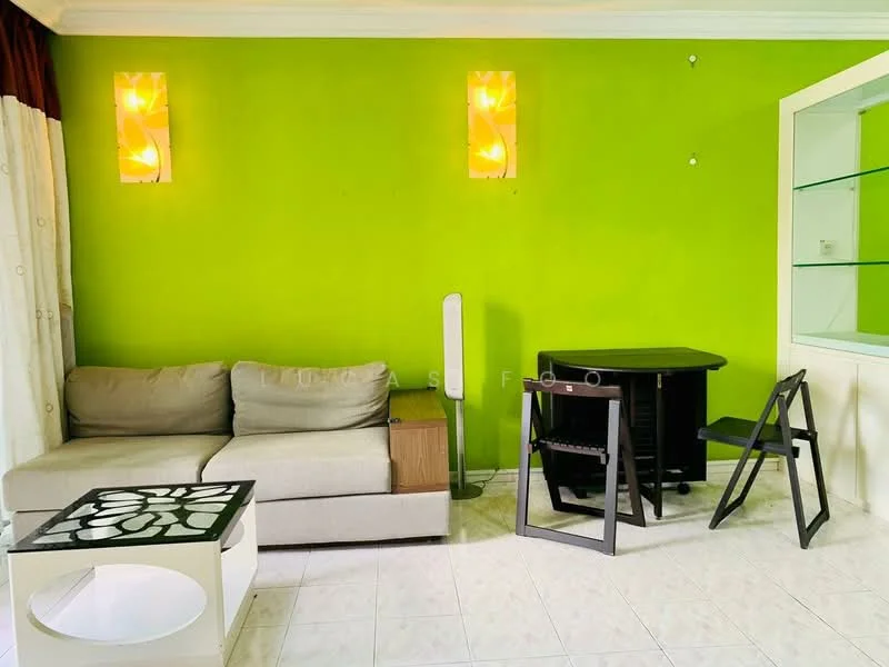 Living features: green painted walls, white tiled flooring, 3-seater fabric sofa in beige, wooden side table, black dining table, black folding chair, decorative wall lights, floor fan; style: modern.
