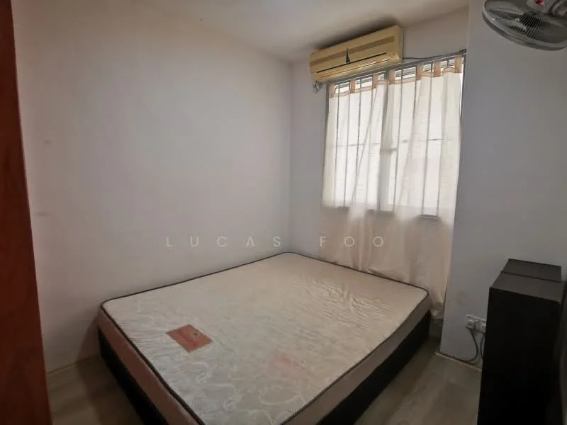 Bedroom features: single bed mattress, wooden flooring, white painted walls, window with sheer curtains, wall-mounted split AC, ceiling fan, nightstand, light switch.
