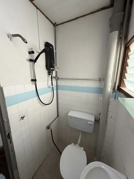 Bathroom features: white tiled walls, light blue accent strip, shower with wall-mounted water heater, toilet, floor tiles, showerhead, grab bar, window for natural light.