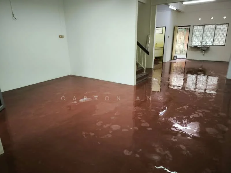 Room features: red polished concrete flooring, white painted walls, staircase leading to upper level, multiple windows for natural light, doorway leading to another room, sink visible in adjacent room.
