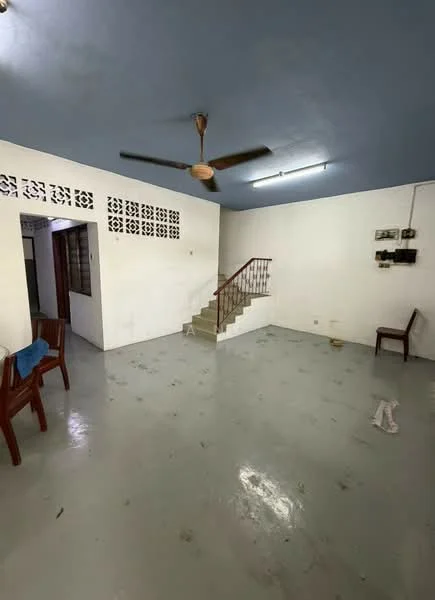 Living features: plain white walls, grey ceiling, polished concrete flooring, 5-blade ceiling fan, staircase leading to upper level, two wooden chairs, wall-mounted electrical panel, open space layout; style: minimalist.