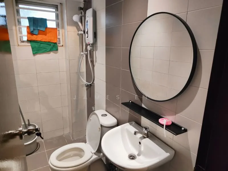 Bathroom features: white tiled walls, grey tiled flooring, round mirror, single-sink vanity with white cabinet, chrome basin mixer faucet, one-piece toilet, shower area with wall-mounted showerhead, shower water heater, black wall shelf, colorful towels hanging; style: modern.