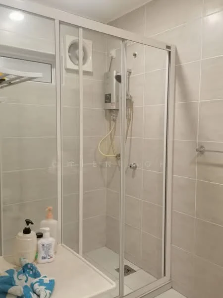 Bathroom features: glass shower enclosure, rain shower head, handheld shower, white tiled walls, grey tiled flooring, built-in shower shelf, wall-mounted water heater, chrome shower valve, sliding glass door, toilet paper holder, soap dispenser, various toiletries on countertop; style: modern.