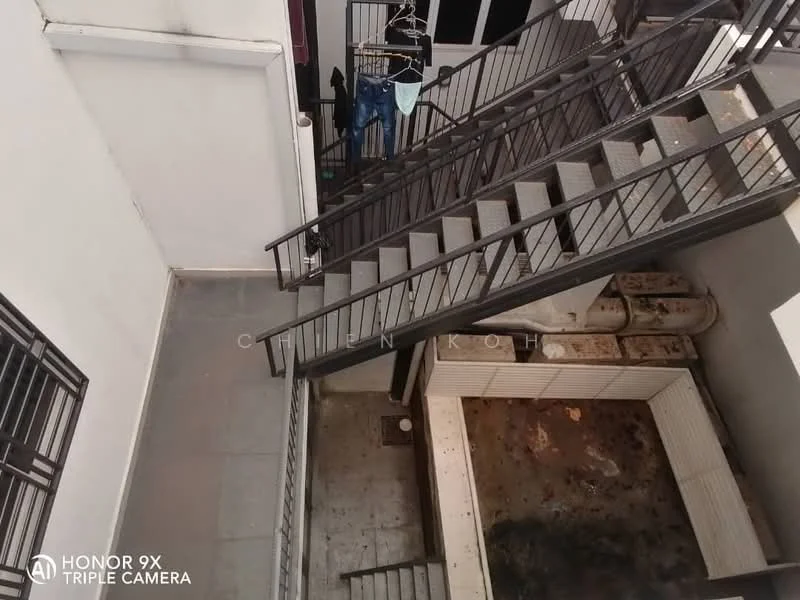 Room features: metal staircase, grey tiled flooring, white painted walls, clothes hanging on a rack, open space, drainage grate, enclosed area with wooden walls, exposed pipes; style: modern.