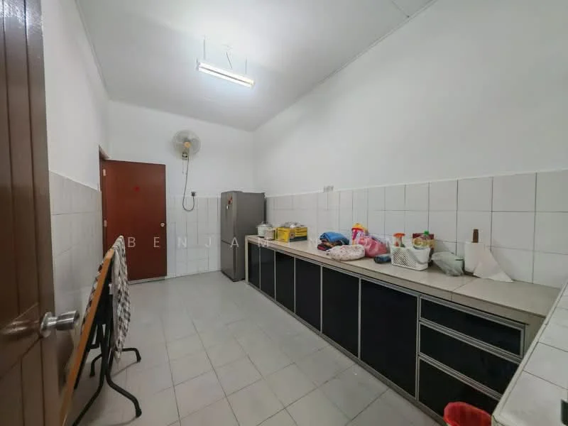 Kitchen features: white tiled walls, grey tiled flooring, laminate countertop, black cabinetry, stainless-steel fridge, wall-mounted fan, single-bowl stainless-steel sink, built-in storage cabinets, overhead fluorescent lighting.