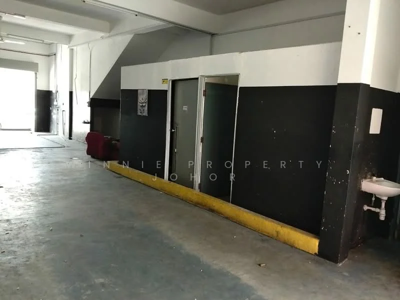 Room features: grey concrete flooring, black painted walls, white painted walls, door to a room, sink mounted on wall, yellow skirting board, large open space, exposed ceiling; style: industrial.