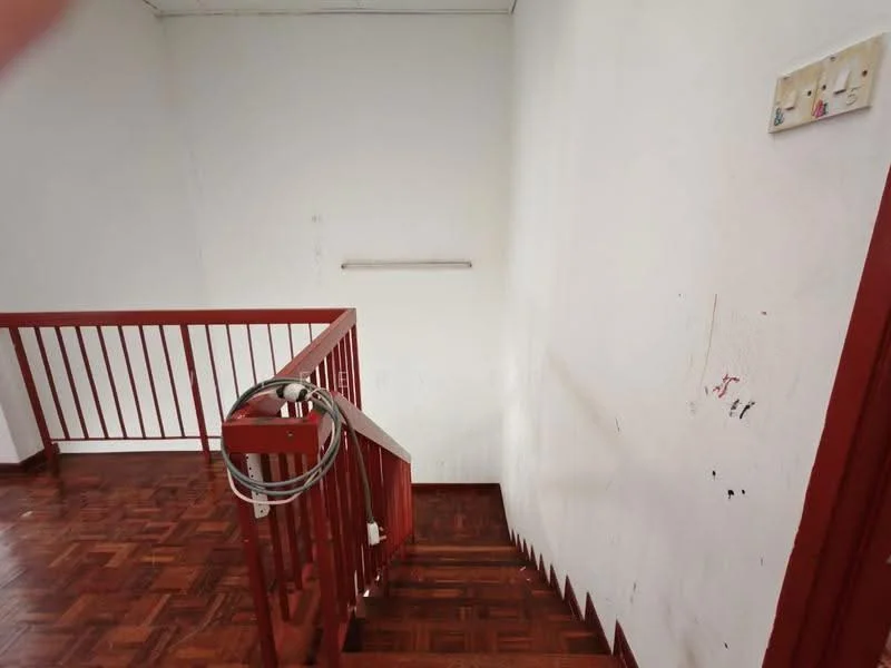 Room features: wooden flooring, white painted walls, red railing, staircase, light fixture, wall-mounted electrical outlets.