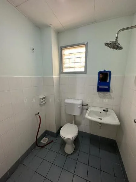 Bathroom features: white tiled walls, light blue painted walls, grey floor tiles, one-piece toilet, wall-mounted sink, chrome shower head, window with horizontal slats, soap dispenser, toilet paper holder.