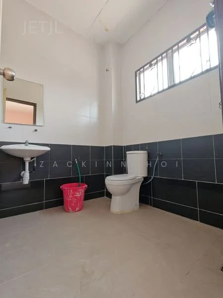 Bathroom features: white ceramic toilet, single-sink vanity with wall-mounted mirror, black tiled walls, white tiled walls, grey floor tiles, window for natural light, pink plastic bucket.