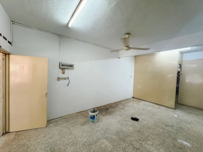 Room features: white painted walls, polished concrete flooring, ceiling fan, wall-mounted air conditioning unit, single door, light fixtures, bucket on the floor, shoe on the floor.