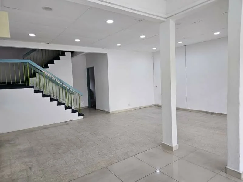 Room features: white painted walls, tile flooring, recessed downlights, staircase with green railing, open layout, large open space, neutral color scheme, no visible furniture; style: modern.