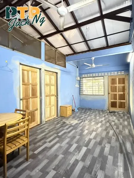 Room features: blue painted walls, exposed metal beams, wooden doors, floor-to-ceiling windows, ceiling fan, laminate flooring, round dining table, 4 wooden chairs, wooden storage cabinet, broom visible, natural light from windows.