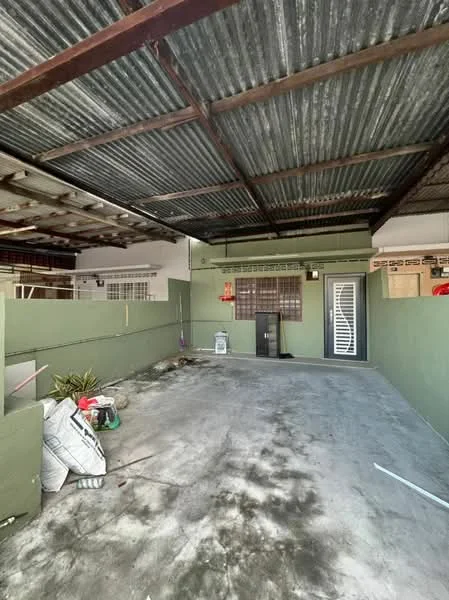 Room features: concrete flooring, green painted walls, metal roof with exposed beams, sliding door, window with metal grille, unfinished space, outdoor area, storage items present.