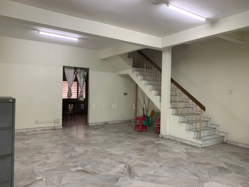 Room features: marble flooring, white painted walls, staircase with wooden railing, ceiling lights, large window, open layout, corner space, two red plastic chairs.