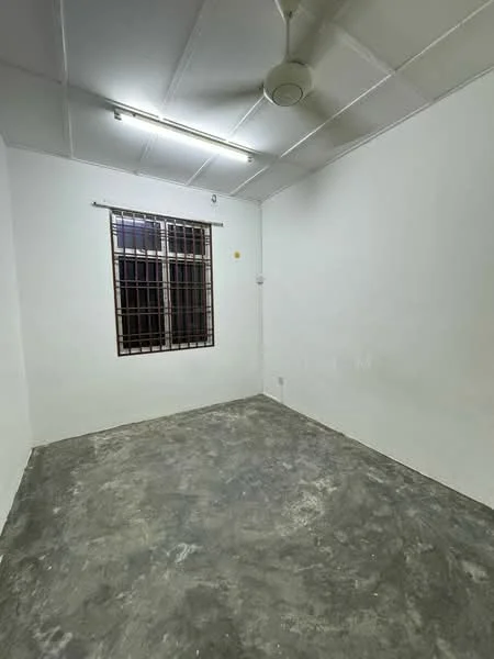 Room features: white painted walls, concrete flooring, ceiling fan, window with security bars, fluorescent lighting.