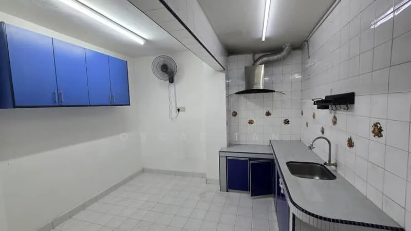 Kitchen features: blue cabinetry, stainless-steel sink, chrome faucet, grey countertop, white tiled backsplash, white tiled flooring, exhaust hood, wall-mounted fan, decorative wall tiles with floral pattern, fluorescent ceiling lights.