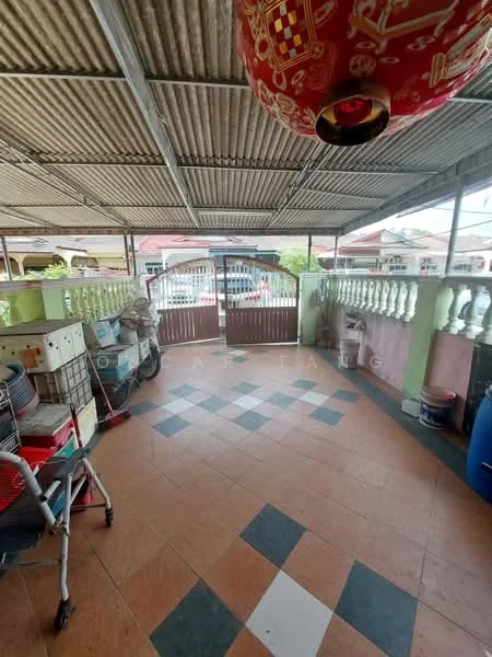 Room features: tiled flooring with checkerboard pattern, metal roof with exposed beams, decorative lantern hanging from ceiling, railing with decorative balusters, open space with natural light, outdoor view through open door, storage boxes, broom and cleaning equipment; style: traditional; view: garden.
