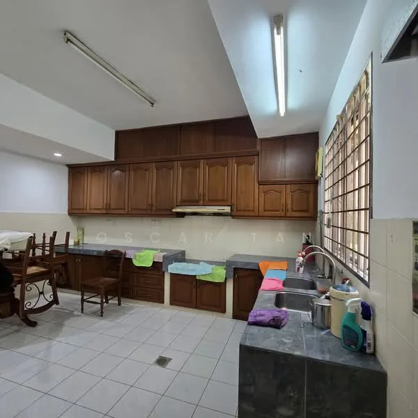 Kitchen features: brown wooden cabinetry, grey granite countertops, double-bowl stainless-steel sink, chrome pull-down faucet, built-in range hood, tile backsplash, white tiled flooring, fluorescent ceiling lights, window with metal grille, dining table with wooden chairs, colorful cloths on countertops.