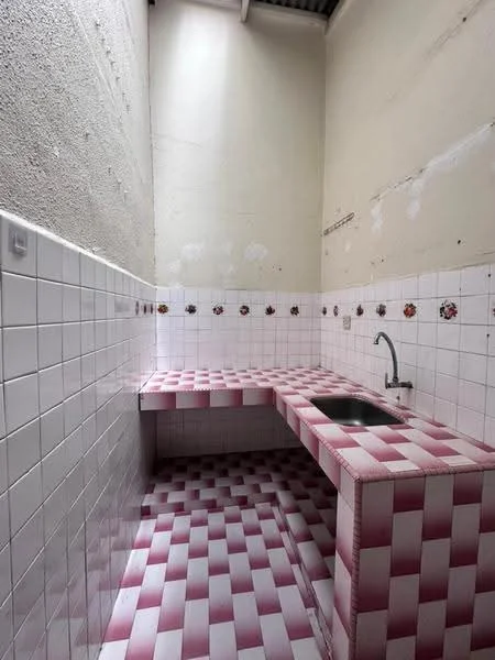 Room features: white tiled walls, pink and white checkered tile flooring, single-bowl stainless-steel sink, chrome faucet, countertop with pink and white checkered tiles, decorative floral tile border.