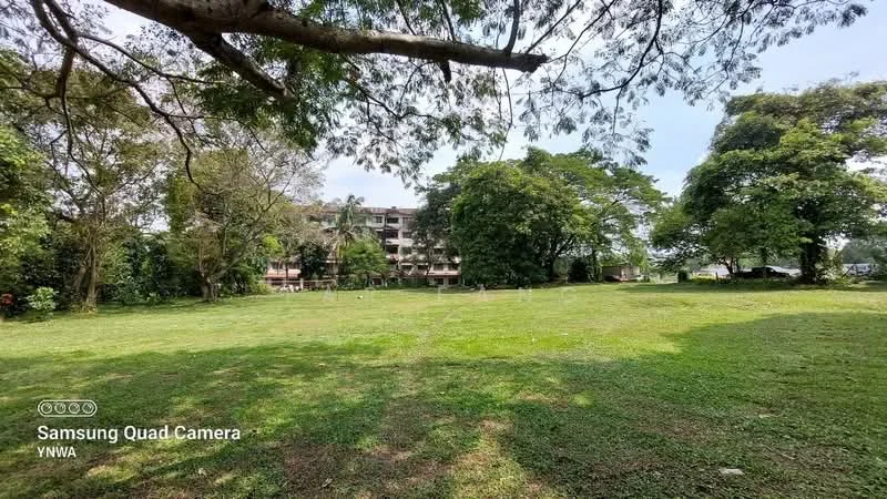 Exterior type: low-rise apartment block; features: manicured lawn, mature trees, surrounded by greenery, 3-storey building, balconies visible on upper floors, parking area visible, open space, landscaped garden; style: modern.
