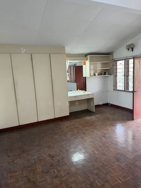 Room features: wooden flooring, cream painted walls, built-in cabinets, mirror above desk, window with grid design, desk area, light fixture on ceiling, red door.