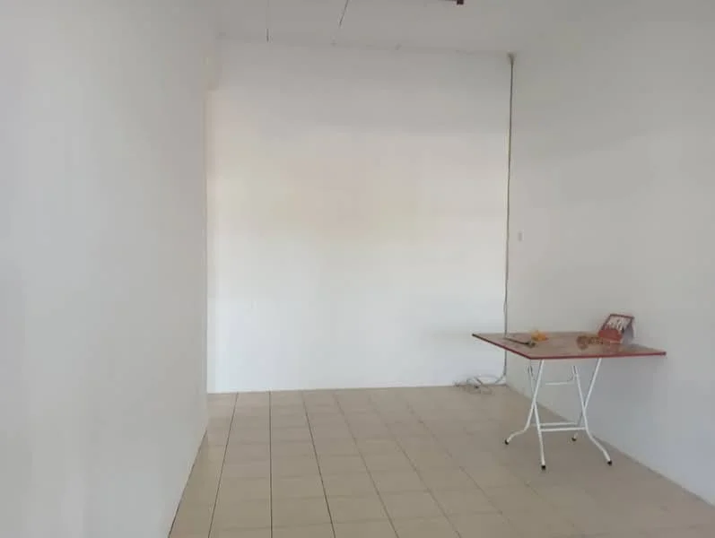 Room features: white painted walls, tile flooring, small table, electrical outlets visible.