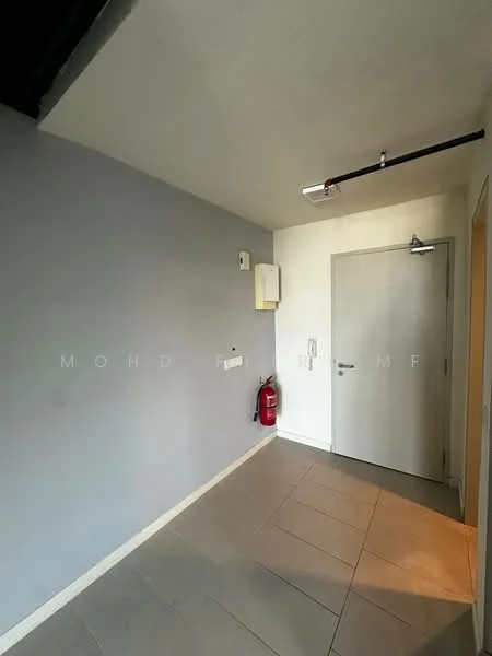 Hallway features: grey painted walls, white painted walls, tile flooring, fire extinguisher, door with handle, light fixture on ceiling, wall-mounted electrical panel, corner wall.