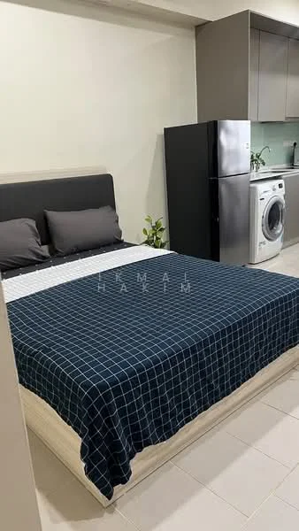 Bedroom features: queen-size bed with checkered bedding, upholstered headboard, 2 grey pillows, black refrigerator, white washing machine, kitchenette with grey cabinetry, green backsplash, tile flooring, indoor plant; style: modern.