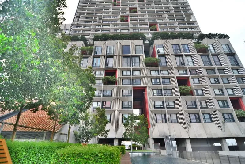Exterior type: high-rise condominium; features: glass curtain wall, exposed concrete facade, recessed balconies, vertical fins, landscaped greenery on balconies, water feature in foreground, manicured hedges, modern architectural design; style: modern.