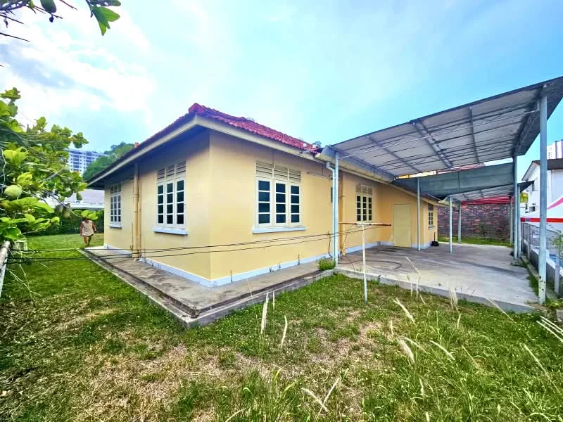 Exterior type: detached bungalow; features: yellow painted facade, red pitched tile roof, single-storey, surrounded by grass lawn, carport with metal roofing, windows with white frames, exposed brick wall at the back, manicured garden area; style: traditional.