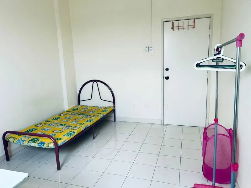 Room features: single bed frame with mattress, yellow patterned bedspread, white tiled flooring, plain white walls, door with handle, clothes rack, pink laundry basket, wall-mounted hooks; style: minimalist.