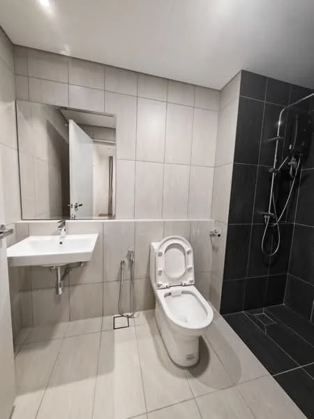 Bathroom features: white ceramic toilet, single-sink vanity with white countertop, chrome basin mixer faucet, framed mirror, walk-in shower with glass enclosure, handheld shower, black tile flooring, light grey wall tiles, grey accent wall, shower wall with black tiles, towel rail, floor drain; style: modern.