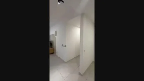 Room features: white painted walls, tile flooring, recessed downlights, wall-mounted switches, corner wall, open space layout; style: modern.