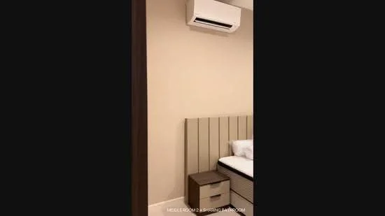 Bedroom features: cream painted walls, wooden flooring, single bed, upholstered headboard, nightstand, wall-mounted air conditioning unit, bed linens, decorative wall art; style: modern.