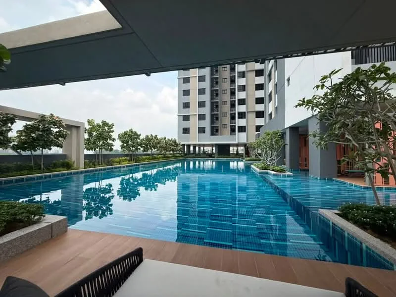 Exterior type: high-rise condominium; features: infinity pool, pool deck with loungers, landscaped garden with trees, modern architectural design, glass facade, surrounding greenery; style: modern.