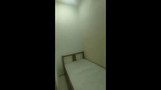 Room features: single bed, plain white walls, tile flooring, ceiling light, no visible decor; style: minimalist.