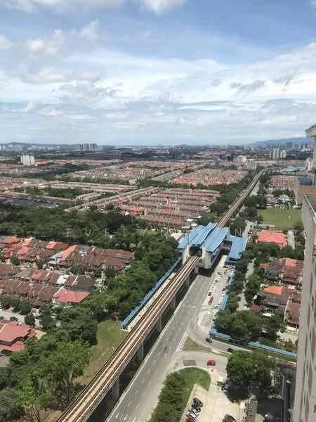 Exterior type: high-rise condominium; features: city skyline view, surrounded by residential areas, elevated train tracks, main road visible, greenery in the foreground, urban landscape, multiple housing developments, blue train station structure; style: modern.