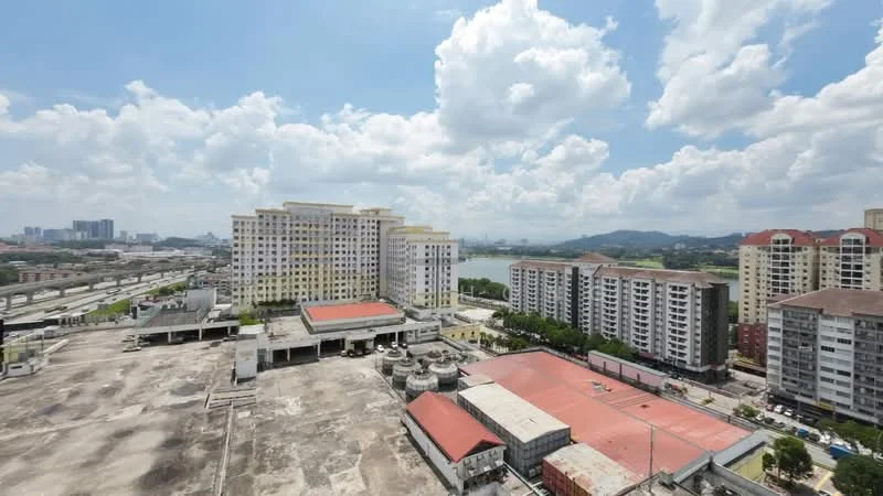 Exterior type: mid-rise condominium; features: multiple mid-rise buildings, surrounding parking area, open space with concrete surface, view of city skyline, green landscaping, near water body, highway visible in background; style: modern.