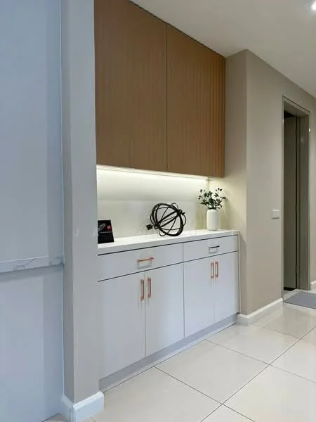 Room features: white cabinetry with orange handles, wooden upper cabinets, white countertop, decorative orb sculpture, potted plant, LED strip lighting under cabinets, neutral wall color, ceramic tile flooring; style: modern.