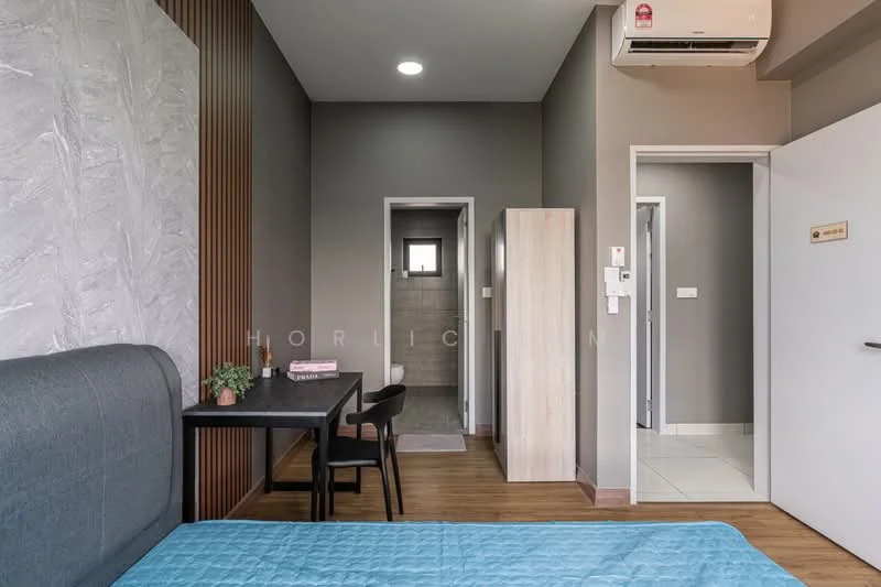 Room features: grey accent wall, light brown laminate flooring, white painted walls, 1 wall-mounted split AC, bed with blue bedding, small black dining table, black chair, wooden wardrobe, doorway leading to bathroom, doorway leading to hallway, recessed ceiling lights; style: modern.