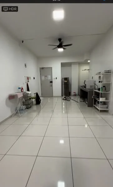Room features: white painted walls, glossy ceramic tile flooring, 5-blade ceiling fan, recessed LED downlights, kitchenette with countertop, stainless-steel fridge, open shelving unit, laundry area with washing machine, wall-mounted mirror, door leading to hallway, door leading to bathroom, cleaning supplies on shelving; style: modern.