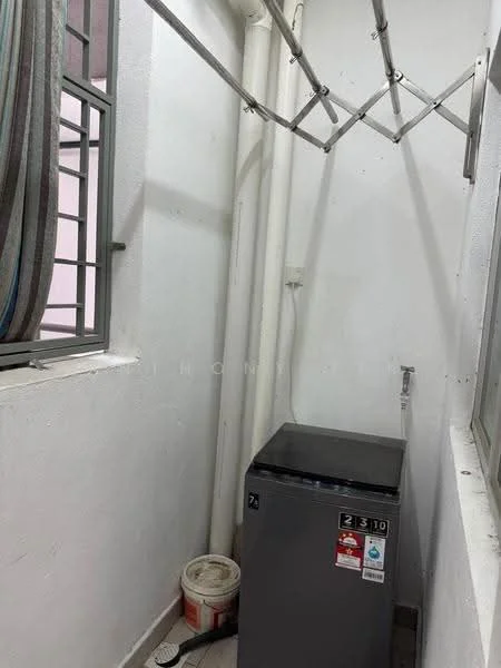 Laundry features: grey washing machine, white walls, tile flooring, window with metal grille, clothes drying rack, plumbing connection, paint bucket, exposed pipes.