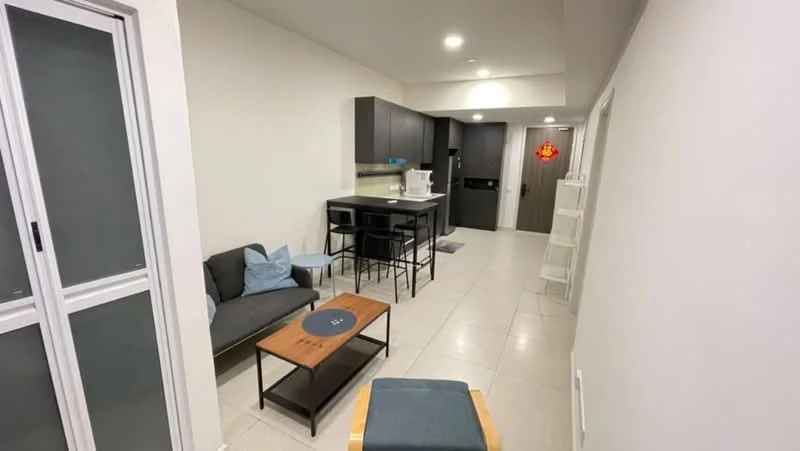 Living features: light grey walls, white ceiling, recessed downlights, large window with sheer curtains, 3-seater fabric sofa in dark grey, wood coffee table, black dining chairs, kitchen island with bar stools, ceramic tile flooring, open-plan layout with kitchen, built-in cabinetry, kitchen appliances visible; style: modern.