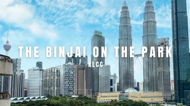 Exterior type: high-rise condominium; features: glass curtain wall, recessed balconies, surrounded by mature greenery, city skyline view, proximity to Petronas Twin Towers; style: modern.