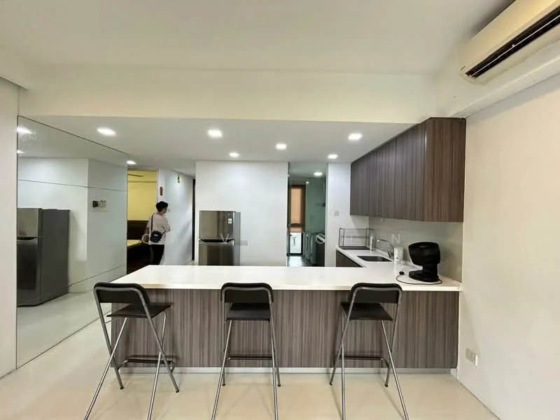 Kitchen features: white quartz countertop, brown wood cabinetry, stainless-steel fridge, built-in oven, 4-burner gas hob, black coffee machine, bar seating with three stools, recessed LED downlights, wall-mounted split AC, mirror wall, white tiled flooring; style: modern.