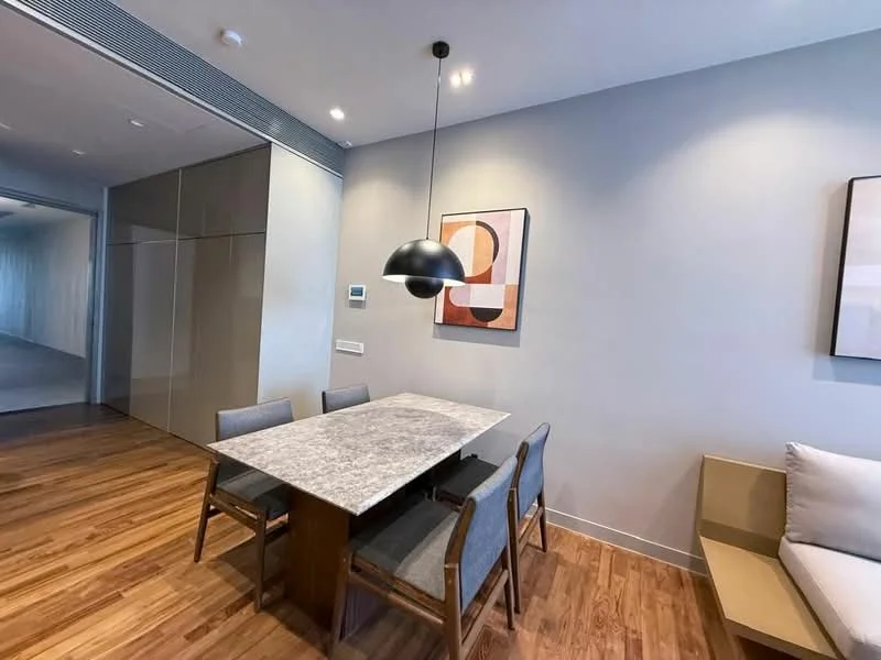 Dining features: marble dining table, 4 wooden dining chairs, pendant light fixture, wooden flooring, grey painted walls, framed artwork on wall, wall-mounted control panel, built-in cabinetry, sofa against wall; style: modern.