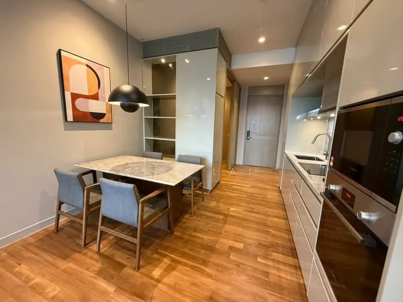 Dining features: wood dining table with marble top, 4 dining chairs with fabric upholstery, pendant lamp, wood flooring, grey painted walls, built-in cabinetry, recessed lighting, open layout to kitchen, kitchen appliances visible, doorway leading to hallway; style: modern. Kitchen features: stainless-steel sink, built-in oven, microwave, stainless-steel range, white cabinetry, countertop with marble finish, recessed downlights; style: modern.