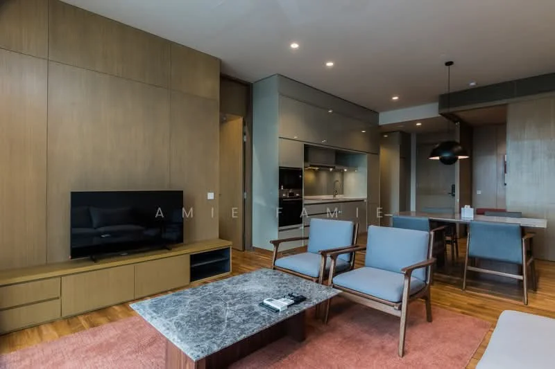 Living features: wooden flooring, light brown painted walls, recessed downlights, wall-mounted TV, wooden TV console, grey fabric armchairs, marble coffee table, area rug with geometric pattern, open-plan layout to kitchen, large windows with natural light; style: modern. Kitchen features: grey cabinetry, black countertop, built-in oven, stainless-steel sink, chrome pull-down faucet, recessed lighting, open shelving, kitchen island, bar stools; style: modern.