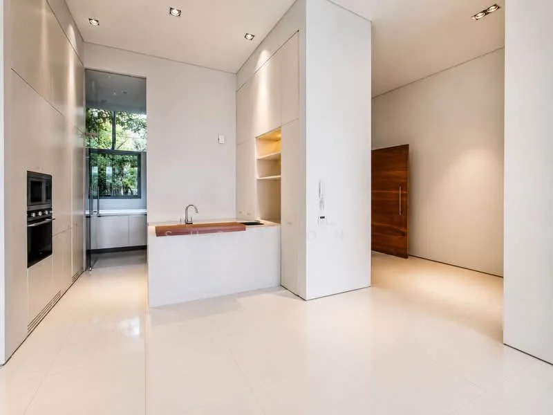 Kitchen features: white cabinetry with flat-panel design, island with integrated sink, single-bowl stainless-steel sink, chrome pull-down faucet, built-in oven, built-in microwave, white quartz countertop, recessed downlights, large window with garden view, polished tile flooring, wooden door, open shelving; style: modern; view: garden.
