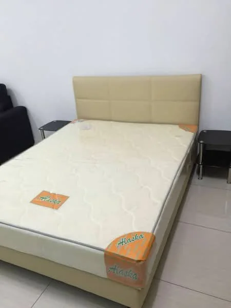 Bedroom features: queen-size bed, upholstered headboard in cream, mattress with protective cover, two bedside tables, white painted walls, tile flooring; style: modern.